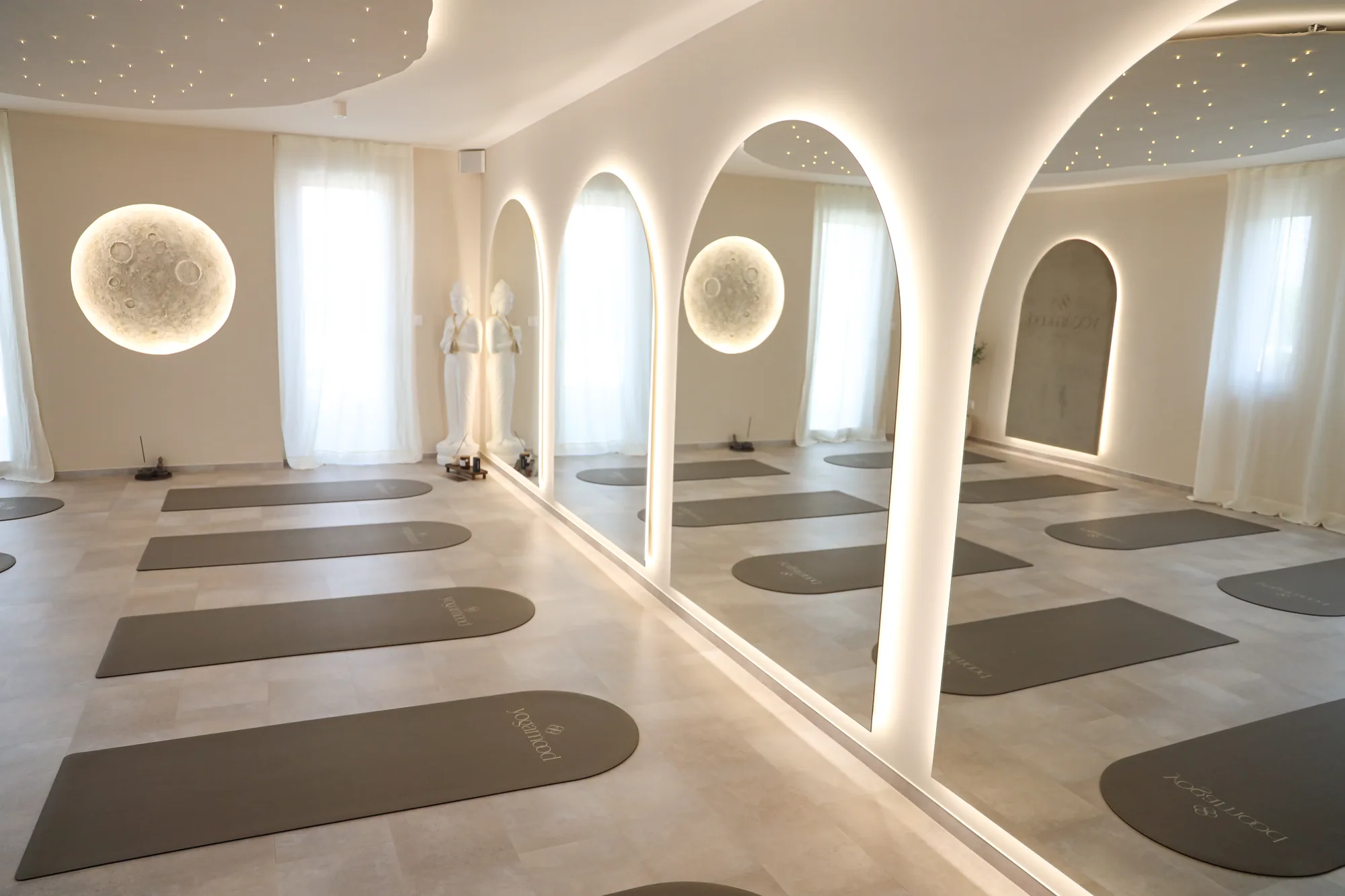 A yogamood studio ívelt oszlopos jógaterme Székesfehérváron, háttérvilágított holdkorongokkal